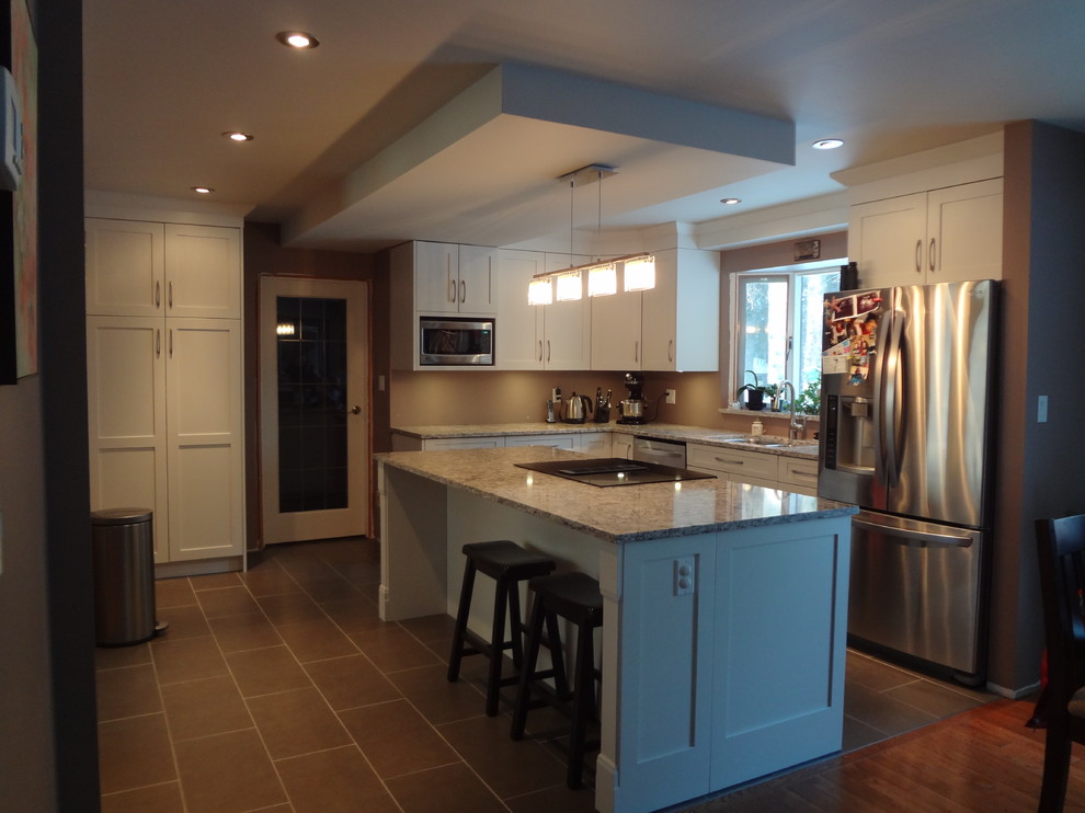 Mid-sized transitional l-shaped porcelain tile and gray floor open concept kitchen photo with an undermount sink, shaker cabinets, white cabinets, quartz countertops, stainless steel appliances, an island and multicolored countertops