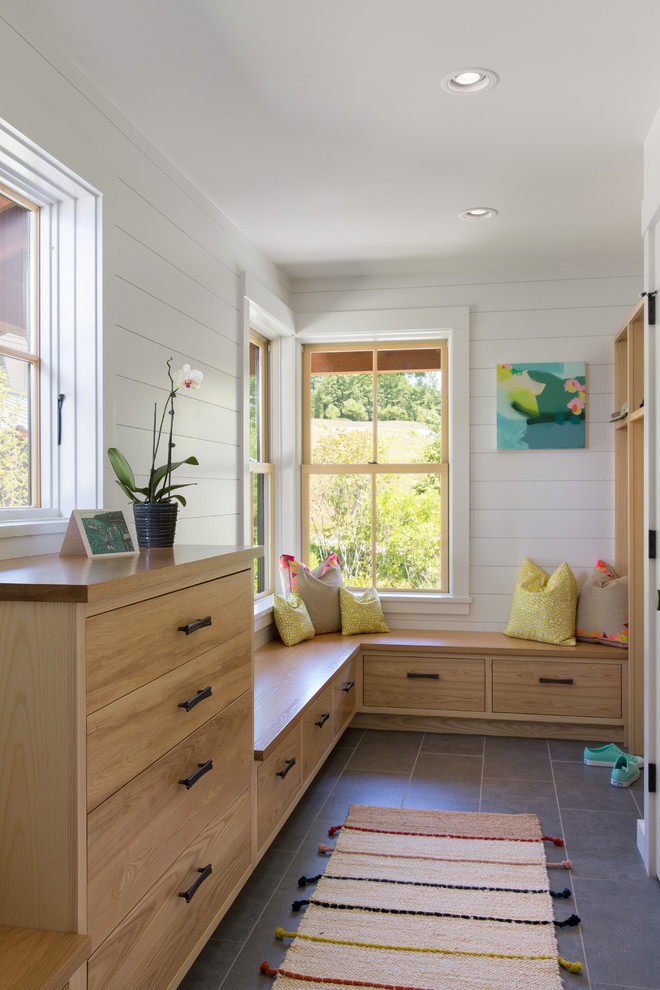 This is an example of a mid-sized transitional mudroom in Portland Maine with porcelain floors, white walls, a medium wood front door and grey floor.
