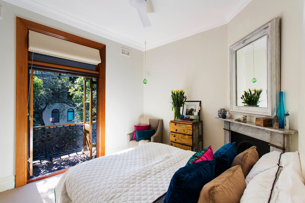 Photo of a transitional bedroom in Sydney with white walls, carpet and a standard fireplace.