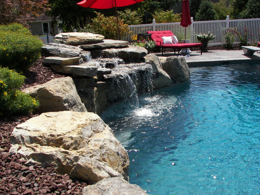 Traditional backyard custom-shaped natural pool in Philadelphia with stamped concrete.