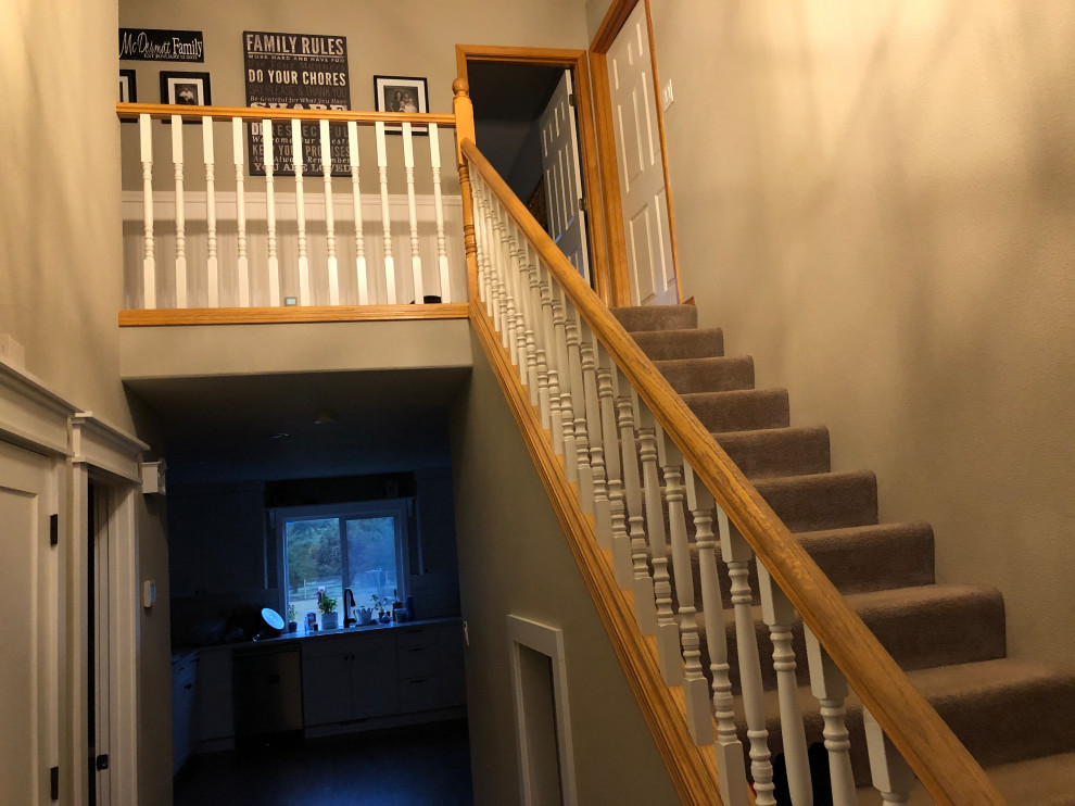 Large classic wood straight wood railing staircase in Portland with wood risers.