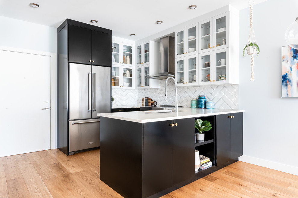 Small transitional u-shaped eat-in kitchen in Other with an undermount sink, glass-front cabinets, black cabinets, quartz benchtops, white splashback, porcelain splashback, stainless steel appliances, light hardwood floors, a peninsula, brown floor and yellow benchtop.