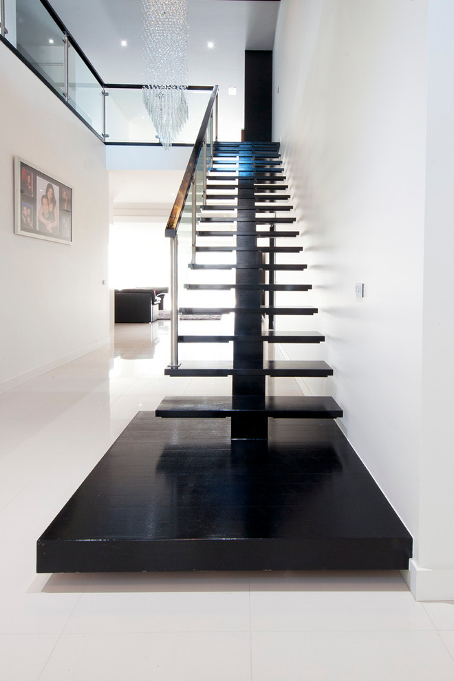 This is an example of a mid-sized contemporary wood straight staircase in Melbourne with open risers.