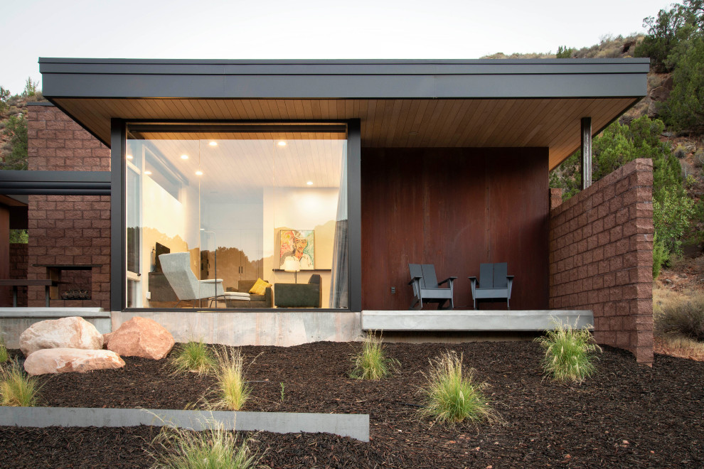 Aménagement d'une façade de maison métallique moderne de plain-pied avec un toit plat, un toit en métal et un toit noir.