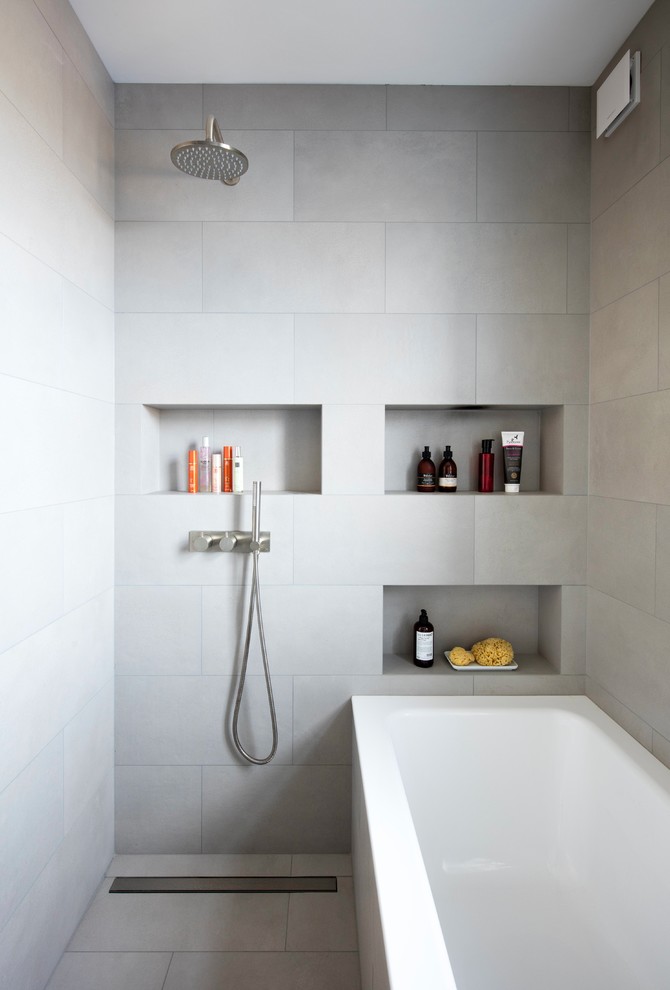 Design ideas for a small contemporary wet room bathroom in London with light wood cabinets, a wall-mount toilet, porcelain tile, grey walls, porcelain floors, concrete benchtops, grey floor, an open shower, a drop-in tub, gray tile, a wall-mount sink, grey benchtops and a niche.