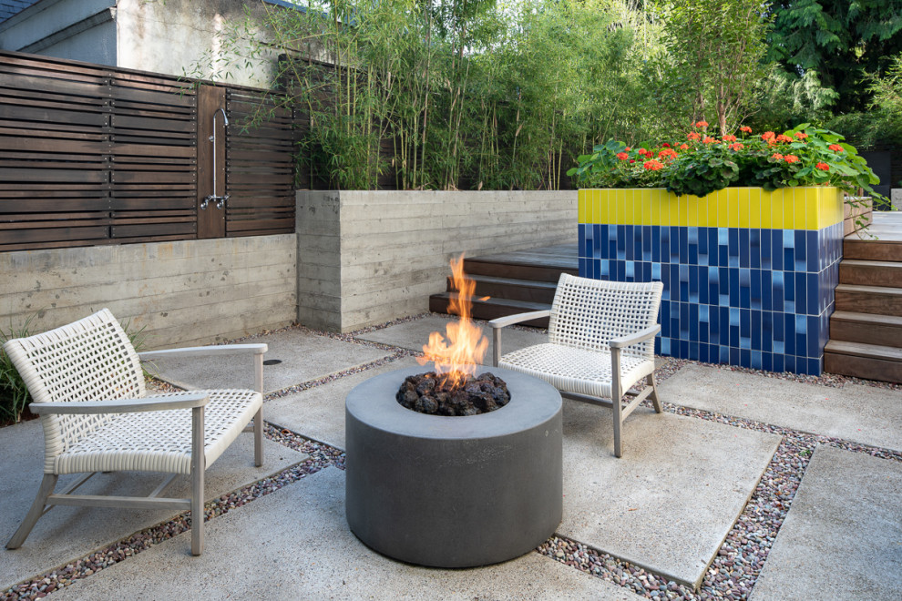 Photo of a small modern back patio in Portland with a fire feature, concrete paving and no cover.