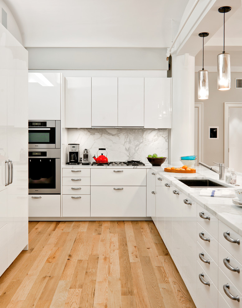 Design ideas for a contemporary l-shaped open plan kitchen in New York with an undermount sink, flat-panel cabinets, white cabinets, marble benchtops, white splashback and marble splashback.