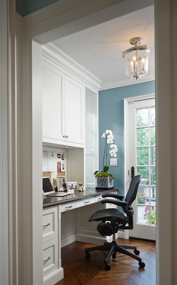 Inspiration for a large traditional study room in Chicago with blue walls, dark hardwood floors and a built-in desk.