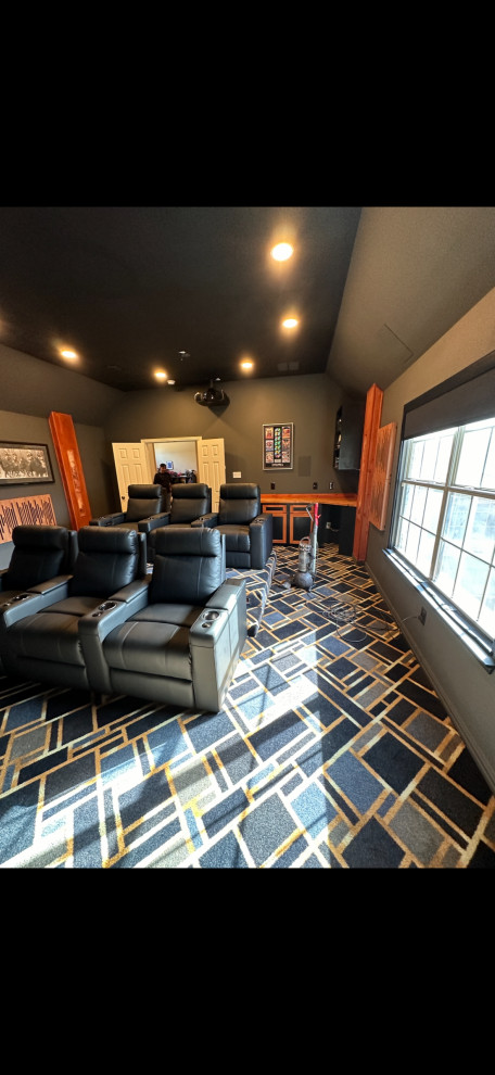Mid-sized modern home theatre in Dallas with grey walls, carpet, a projector screen and black floor.