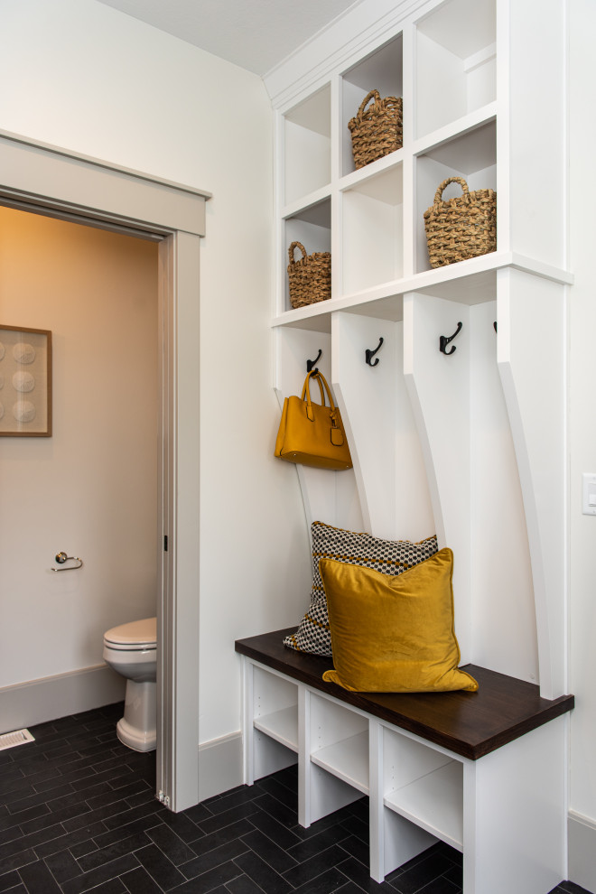 Photo of a mid-sized transitional mudroom in Salt Lake City with white walls, ceramic floors and black floor.