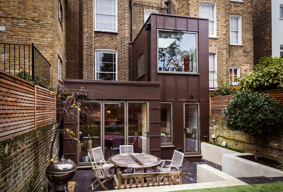 Mid-sized contemporary backyard patio in London with concrete slab and no cover.