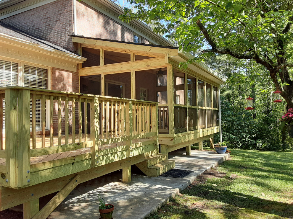 Ejemplo de terraza campestre extra grande en patio trasero y anexo de casas con barandilla de madera