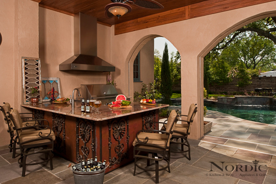 Inspiration for a large traditional backyard patio in New Orleans with an outdoor kitchen, tile and a roof extension.