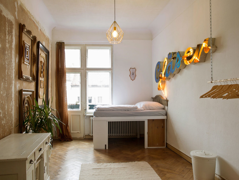 Eklektisches Kinderzimmer mit Schlafplatz, weißer Wandfarbe und braunem Holzboden in Sonstige