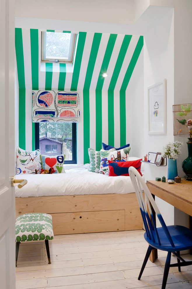 Photo of a mid-sized contemporary gender-neutral kids' bedroom for kids 4-10 years old in London with light hardwood floors and multi-coloured walls.