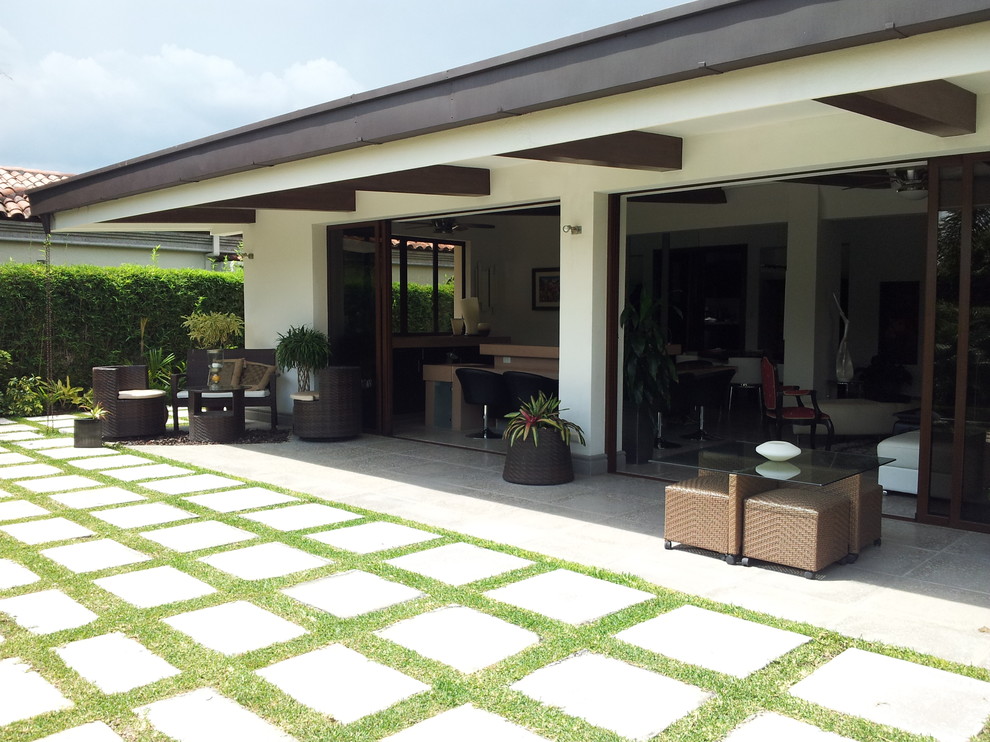 Photo of a contemporary patio in Other with a roof extension.
