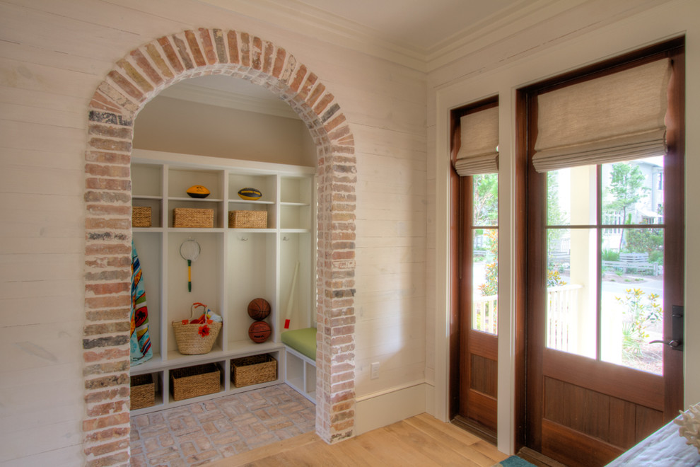 Design ideas for a large beach style mudroom in Miami with brick floors, white walls, a single front door and a medium wood front door.
