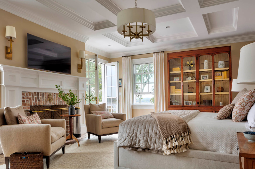 This is an example of a traditional master bedroom in Baltimore with beige walls, dark hardwood flooring, a standard fireplace, a brick fireplace surround, brown floors, a coffered ceiling and a chimney breast.