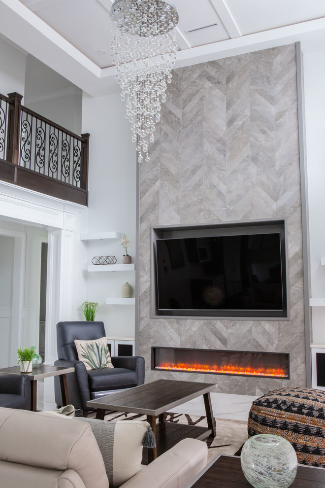 This is an example of a large contemporary enclosed family room in Vancouver with white walls, marble floors, a ribbon fireplace, a tile fireplace surround, a wall-mounted tv and white floor.