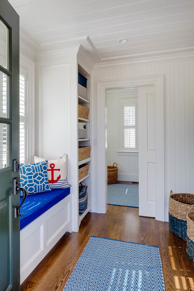 Beach style mudroom in Boston with white walls and medium hardwood floors.