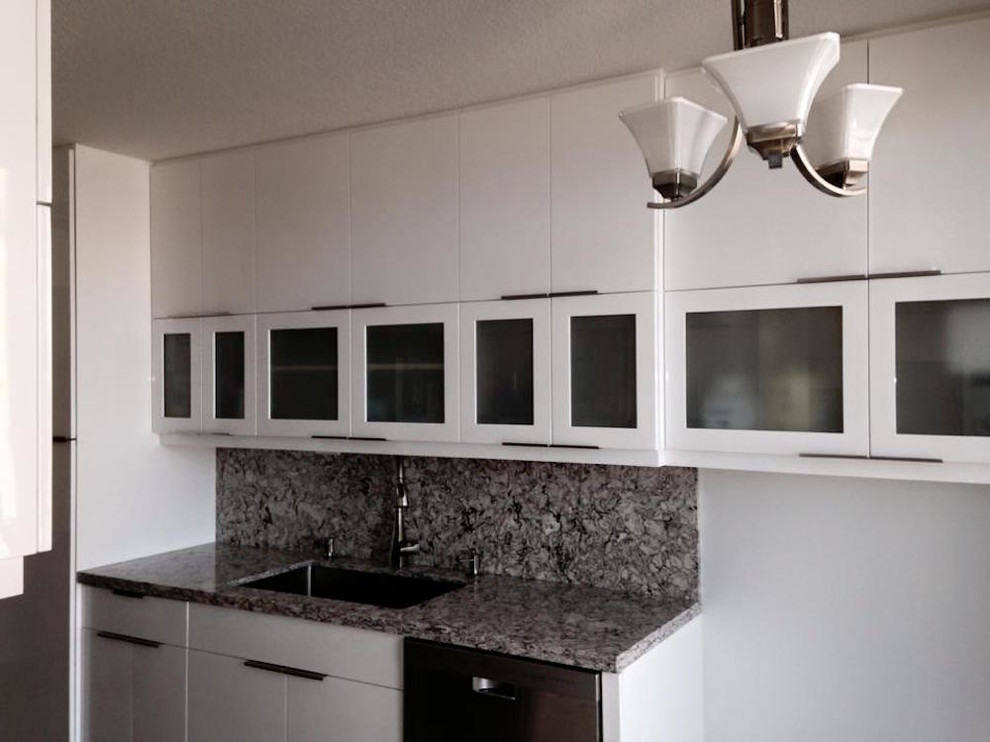 Inspiration for a mid-sized transitional galley enclosed kitchen remodel in Miami with an undermount sink, flat-panel cabinets, white cabinets, granite countertops, multicolored backsplash and stone slab backsplash