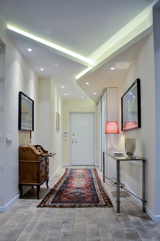 Mid-sized contemporary entry hall in Milan with light hardwood floors, white walls, a single front door and a white front door.
