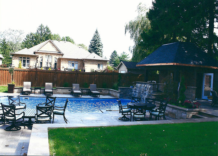 Large transitional backyard stone and rectangular pool fountain photo in Toronto
