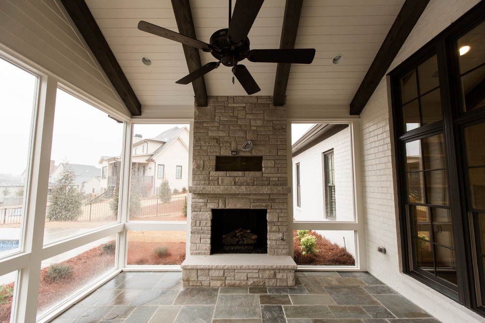 Mid-sized arts and crafts backyard patio in Birmingham with with fireplace, natural stone pavers and a roof extension.