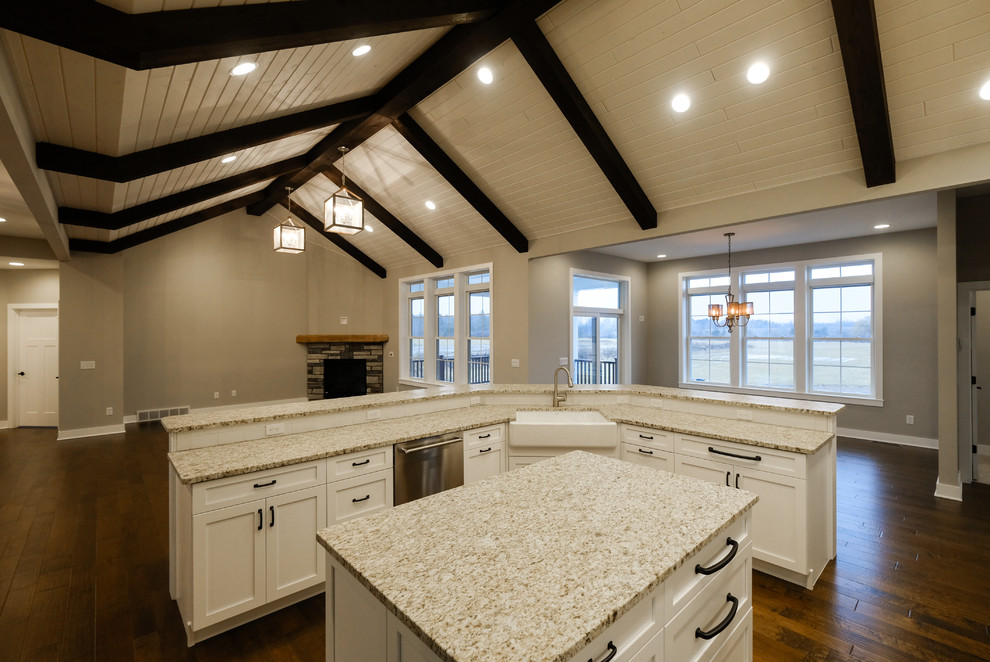 Large transitional l-shaped dark wood floor and brown floor eat-in kitchen photo with a farmhouse sink, recessed-panel cabinets, white cabinets, granite countertops, stainless steel appliances and two islands