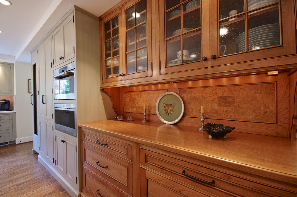 Large traditional l-shaped separate kitchen in Baltimore with a farmhouse sink, beaded inset cabinets, green cabinets, solid surface benchtops, grey splashback, ceramic splashback, stainless steel appliances, medium hardwood floors and with island.
