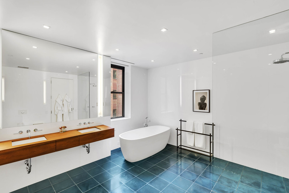 Inspiration for an industrial master wet room bathroom in New York with flat-panel cabinets, medium wood cabinets, a freestanding tub, white walls, an undermount sink, wood benchtops, turquoise floor, an open shower and brown benchtops.