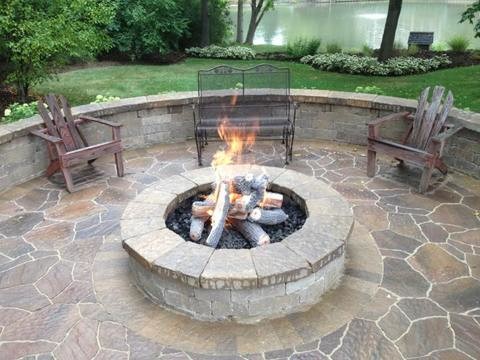 Mid-sized traditional backyard patio in Chicago with a fire feature, natural stone pavers and no cover.