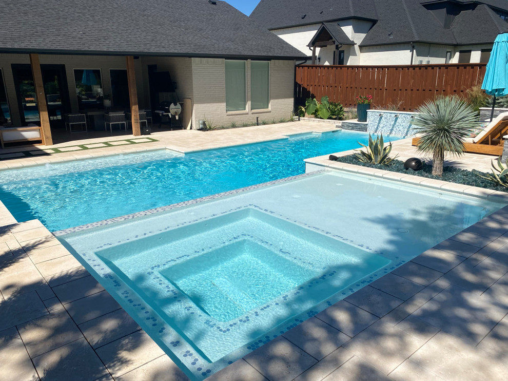 Ispirazione per una grande piscina moderna personalizzata dietro casa con pavimentazioni in pietra naturale