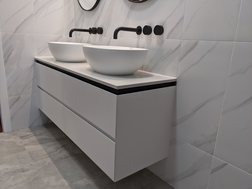 This is an example of a mid-sized modern master bathroom in Brisbane with flat-panel cabinets, white cabinets, white tile, porcelain tile, engineered quartz benchtops, white benchtops, a double vanity and a floating vanity.