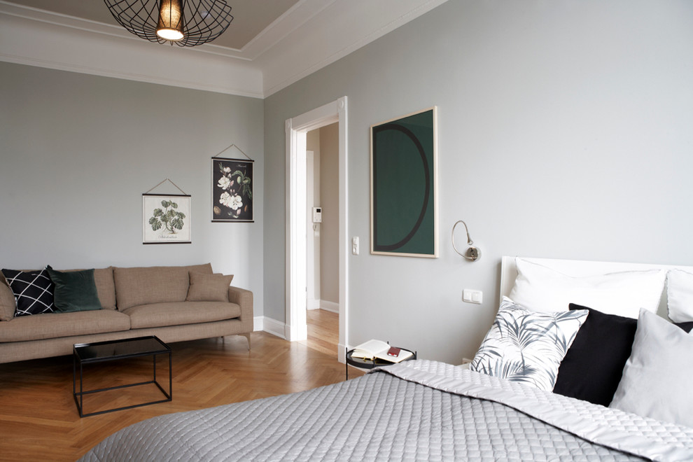 Scandinavian bedroom in Hamburg with grey walls and light hardwood floors.