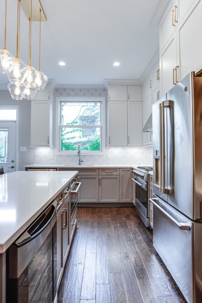 Inspiration for a large transitional l-shaped medium tone wood floor and brown floor eat-in kitchen remodel in DC Metro with an undermount sink, shaker cabinets, white cabinets, solid surface countertops, white backsplash, ceramic backsplash, stainless steel appliances, an island and white countertops
