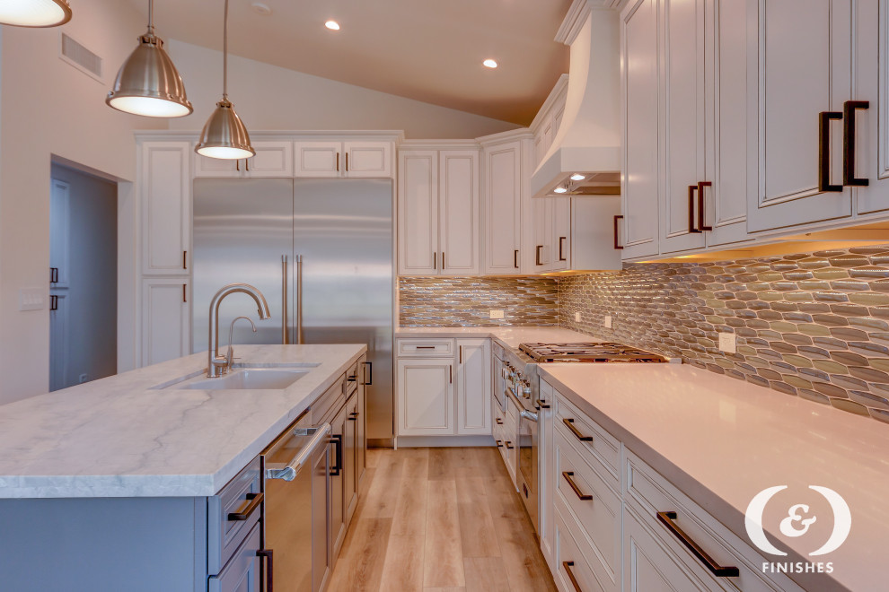 Inspiration for a large transitional u-shaped eat-in kitchen in Phoenix with an undermount sink, flat-panel cabinets, white cabinets, quartz benchtops, multi-coloured splashback, glass sheet splashback, stainless steel appliances, light hardwood floors, with island, beige floor and white benchtop.