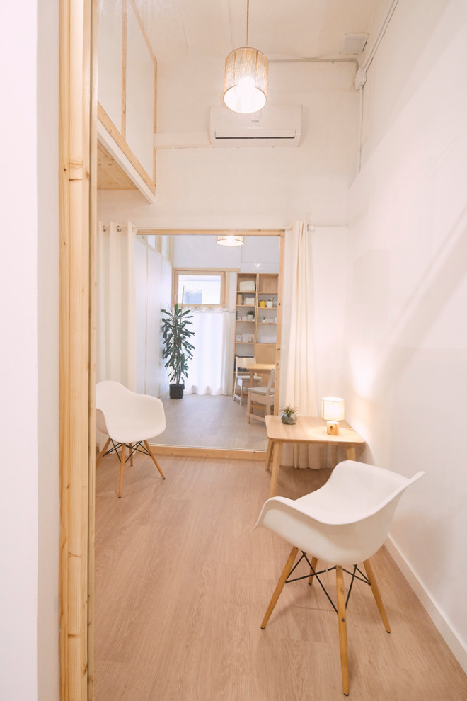 Modelo de sala de estar cerrada y abovedada nórdica pequeña con paredes blancas, suelo de madera clara, suelo beige y madera