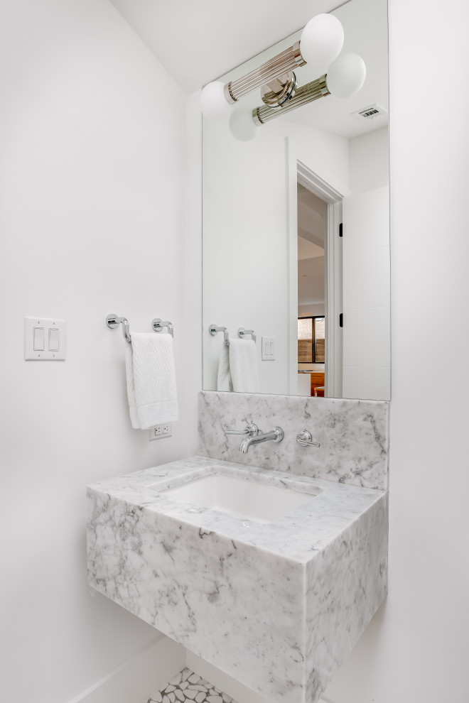 Foto di un grande bagno di servizio minimalista con pareti bianche, pavimento in marmo, lavabo sottopiano, top in marmo, pavimento bianco, top grigio e mobile bagno sospeso