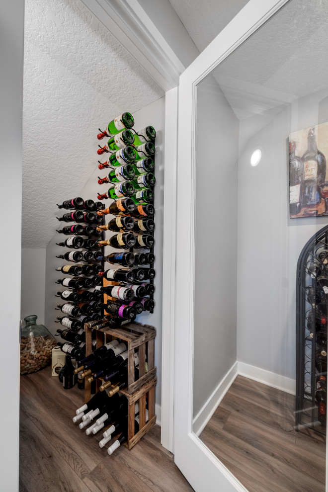Photo of a large traditional wine cellar in Other with vinyl flooring, display racks and brown floors.