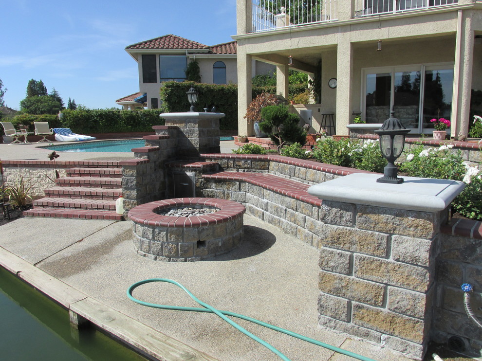 Inspiration for a mid-sized rustic full sun backyard brick landscaping with a fire pit for fall.