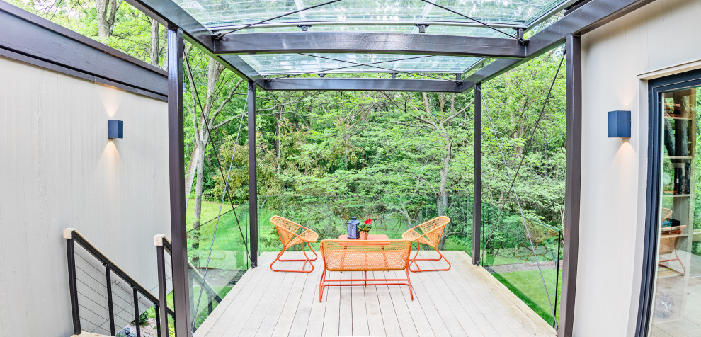Idee per una piccola terrazza minimalista dietro casa e al primo piano con parapetto in vetro