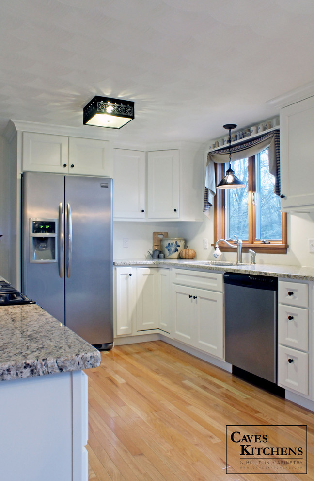 Small transitional u-shaped medium tone wood floor eat-in kitchen photo in New York with an undermount sink, recessed-panel cabinets, white cabinets, granite countertops, white backsplash, stainless steel appliances and no island
