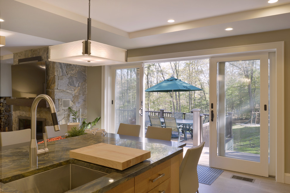 This is an example of a large transitional l-shaped open plan kitchen in New York with an undermount sink, shaker cabinets, medium wood cabinets, granite benchtops, multi-coloured splashback, glass tile splashback, stainless steel appliances, porcelain floors, with island and grey floor.