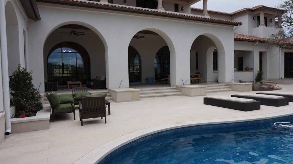 Photo of a large transitional backyard patio in Houston with natural stone pavers.