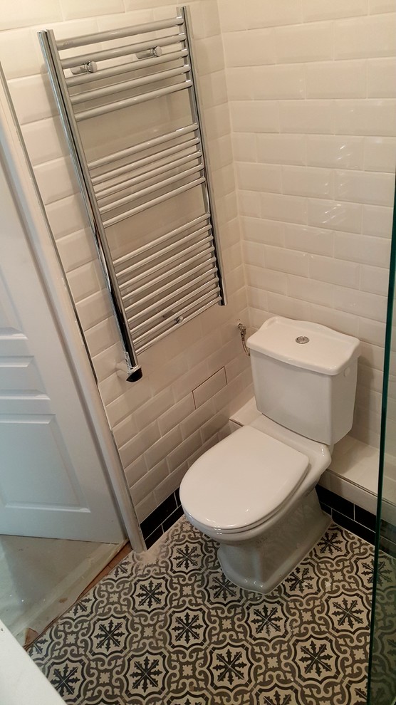 Inspiration for a small traditional powder room in Paris with a one-piece toilet, wood benchtops, beige tile, ceramic tile, beige walls, ceramic floors, a console sink and grey floor.