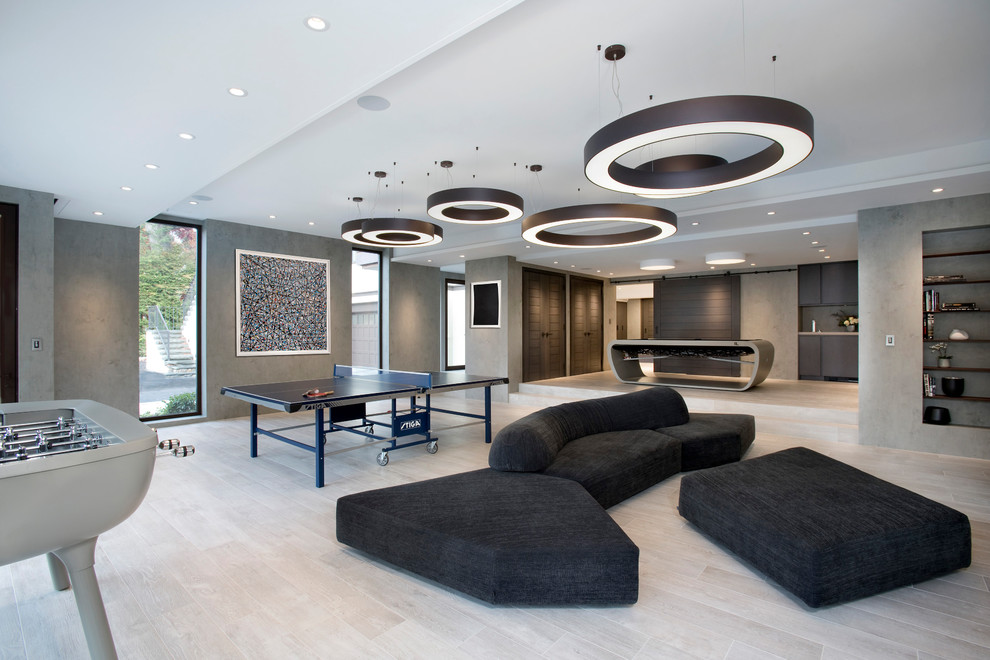 This is an example of a mid-sized contemporary open concept family room in Boston with a game room, grey walls, porcelain floors and grey floor.