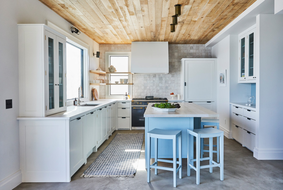 Inspiration for a beach style u-shaped kitchen in New York with shaker cabinets, white splashback, terra-cotta splashback, concrete floors, with island, grey floor, white benchtop and wood.