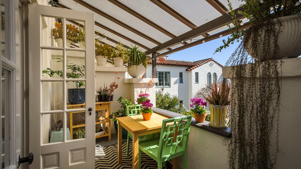 Inspiration for a mediterranean balcony in San Francisco with a container garden and a roof extension.