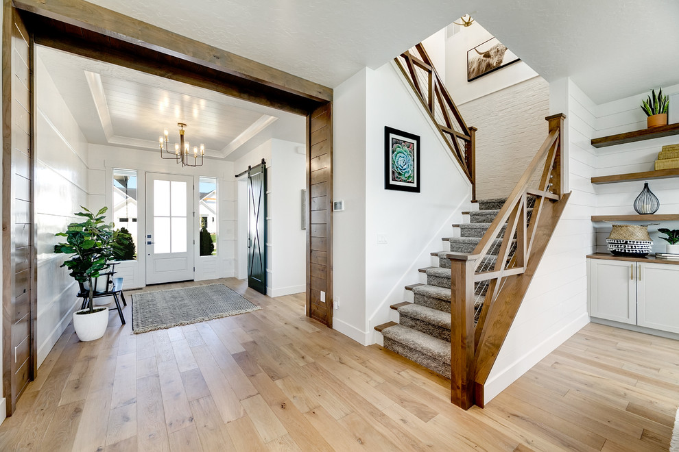 Inspiration for a mid-sized country carpeted u-shaped staircase in Boise with carpet risers and wood railing.